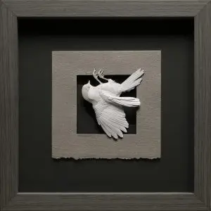 Hand cut paper chickadee by Calvin Nicholls in a frame for display